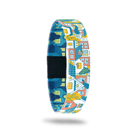 Wristband single with a design of a city block of houses and/or neighborhood. The colors are gold, light orange, blue and white. The inside is the same design but looks like nighttime so all of the houses are blue colored with glowing windows.The inside says Housing Is A Human Right. It comes with a matching charm. 