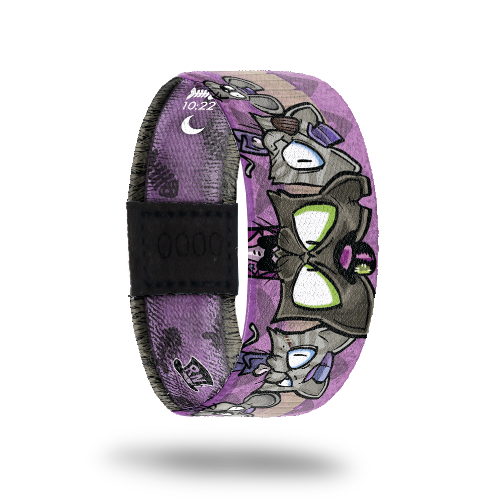 This is a reward item and not purchasable. It is a reversible strap. The design is several "mean" cartoon kitties on a purple base. The inside is also purple and reads Boss Cat. 