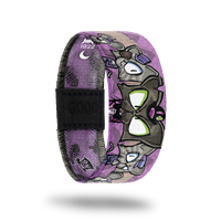 This is a reward item and not purchasable. It is a reversible strap. The design is several "mean" cartoon kitties on a purple base. The inside is also purple and reads Boss Cat. 