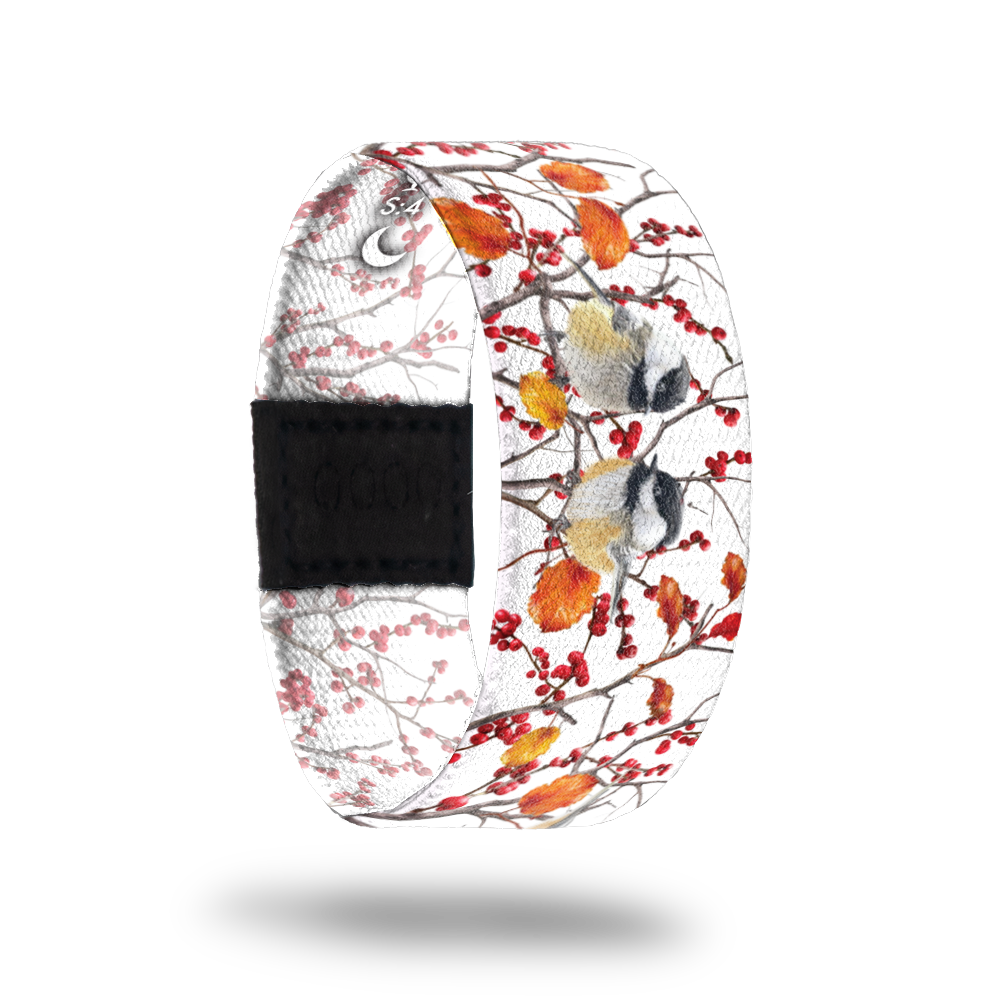 This is a reward and not a purchasble item. It is a reversible strap for the Birds and Blossoms mini collection. The strap is white and has trees with various birds nesting and red berries all over. It comes with a matching lapel pin and the inside reads Choose Serenity. 