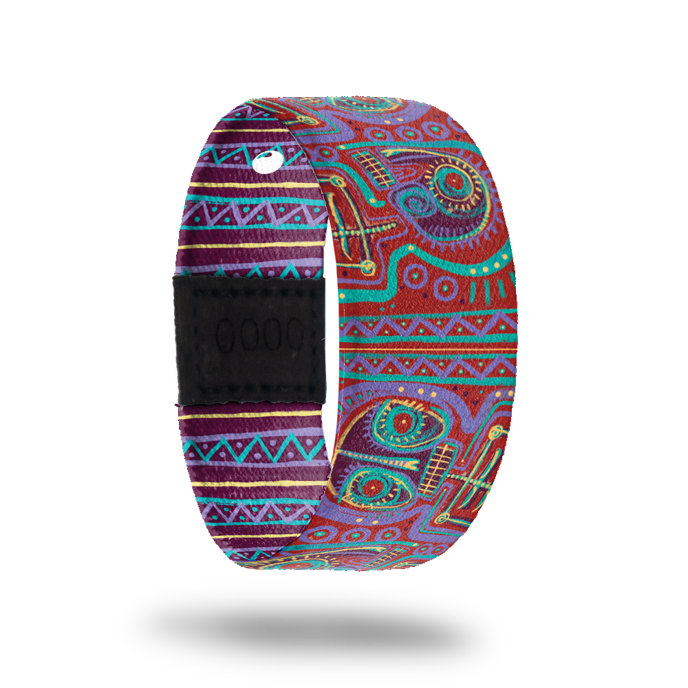 ZOX strap with an abstract design of purple, red, teal and gold. Comes with a matching lapel pin and reads Defy The Odds on the inside. All items come in a matching collector's box. 