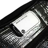 A detail image showing the tag of the smaller backpack where you are able to put the name of who owns the backpack