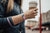 Lifestyle image close up of hand holding a cup of coffee and wearing Hold On