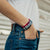 Lifestyle image close up of model's hand in pocket with In This Together on wrist