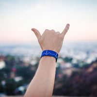 Lifestyle image of hand giving the hang loose sign with Life Saver on wrist 