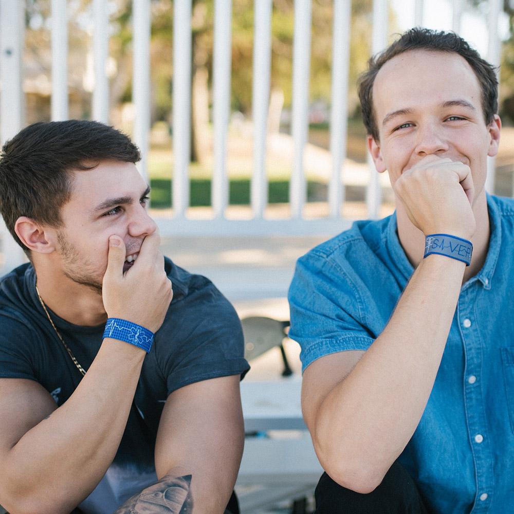 Lifestyle image of two men sitting on porch steps with smiles and both wearing a Life Saver wristband