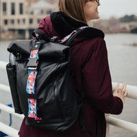 lifestyle photo of the Imperial v2 with a different colored tension and closure straps on a woman's shoulders while looking towards a body of water 
