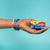 Studio Image of hand holding card that says Stay Curious with a Stay Curious strap on their wrist