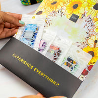 Studio Image of Fairies Pack in custom envelope. Top flap of envelope has Zox logo in the middle with illustrated sunflowers around it. On the bottom pocket of the envelope, that holds the Fairies Pack in their individual white bags, it says Experience Everything in gold reflective coloring