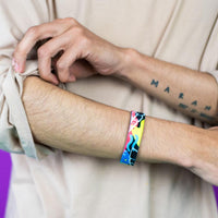 Studio photo of guy rolling up sleeve wearing fortune favors the bold single showing the outside design with hand drawn abstract art