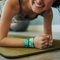 Lifestyle close up of someone holding plank exercise position with 2 Grow Every Day on wrist