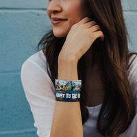 Lifestyle image of 2 Happy To Be Here on wrist of smiling model