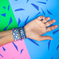 Studio Image of 2 Hug It Out on a wrist in front of a colorful background