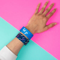Studio Image of 2 Let Go on a wrist in front of a pink and teal background