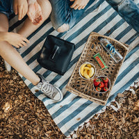 Lifestyle photo of a couple on a picnic with the lunch box capsule on the blanket