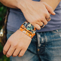 Lifestyle photo of guy wearing two The Path Less Traveled straps showing the inside and outside design