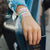 Lifestyle photo of girl holding onto passport wearing two The Places You'll Go straps showing the inside and outside design