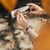 Lifestyle image of hands holding an event ticket with a Spirited Away on their wrist