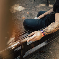 Lifestyle image of arm resting on a bench back with a Spirited Away on wrist