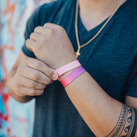 Lifestyle photo of a guy adjusting a no feeling is permanent single above a love yourself showing the outside design with a purple to pink gradient