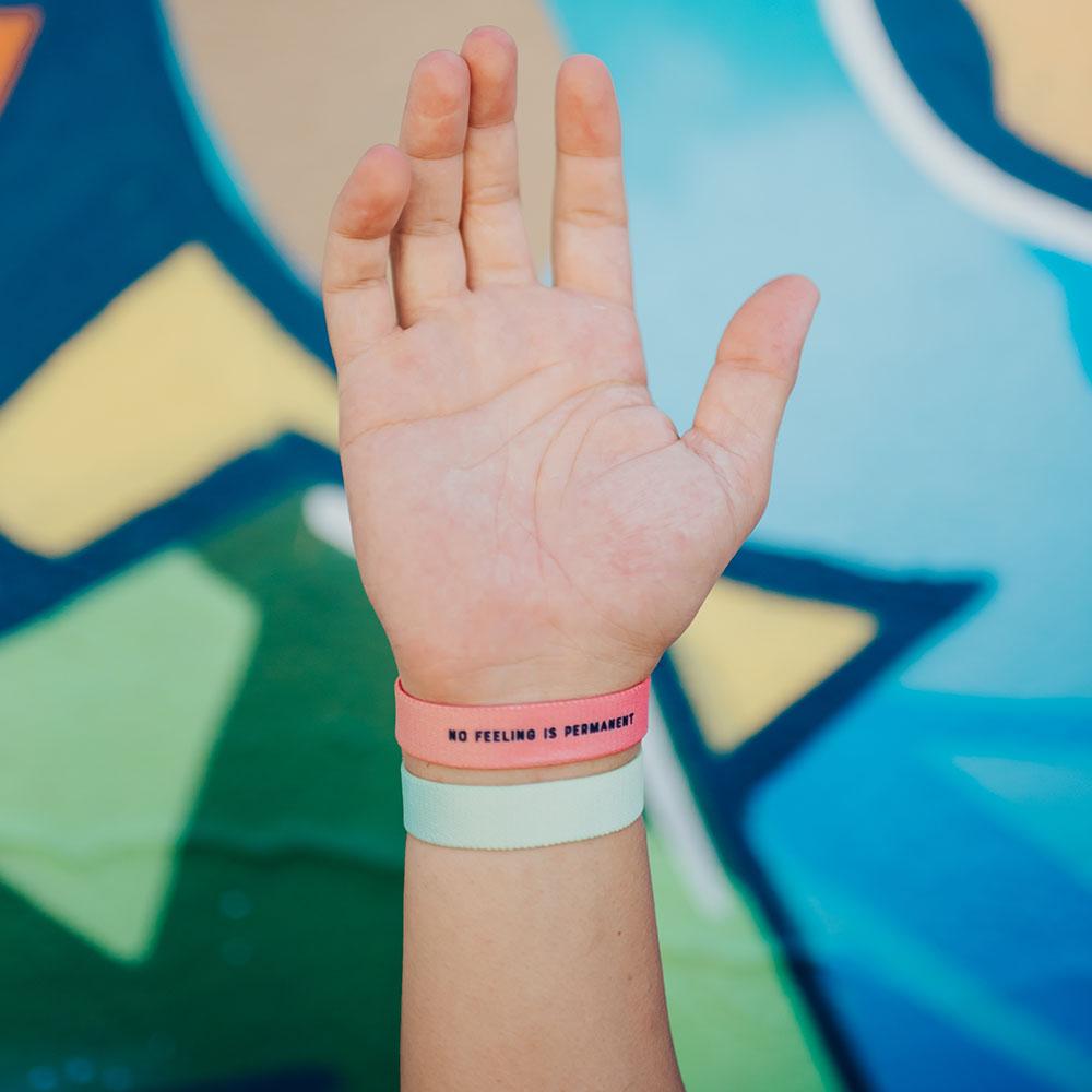 Lifestyle image close up of You Are Perfect For Something and another Zox wristband on model's wrist