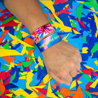 Studio Image of 2 Shatter The Darkness on a wrist in front of a colorful background