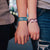 Lifestyle picture of You & Me on models wrists, one blue, one pink.