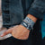 lifestyle photo of a front facing and inside facing Veteran wristband while a man has his hand in his pocket