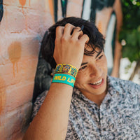 Lifestyle image close up of someone smiling with 2 Wild Life on their wrist 